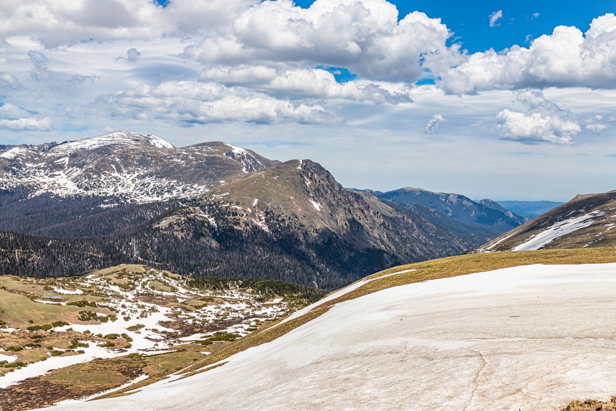 A panoramic view across snowfields and peaks in Rocky Mountain National Park.